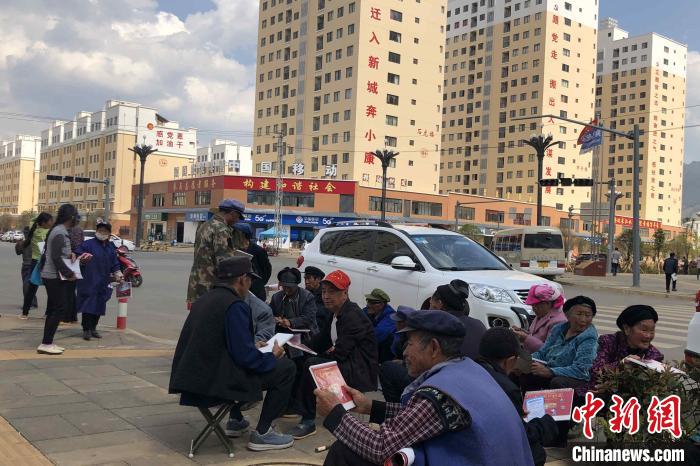 圖為會(huì)澤縣城易地扶貧搬遷安置點(diǎn)內(nèi)，老人們聚在廣場(chǎng)上聊天，身后是他們的新家?！】姵?攝