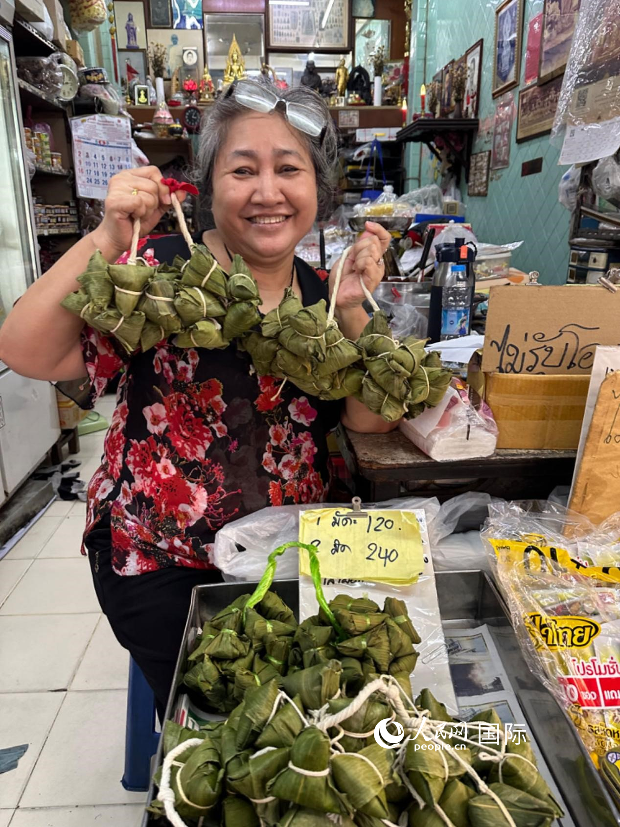 商家向顧客介紹“吉掌”（粽子的一種，一串一串，個頭較小）。人民網(wǎng)記者 簡承淵攝