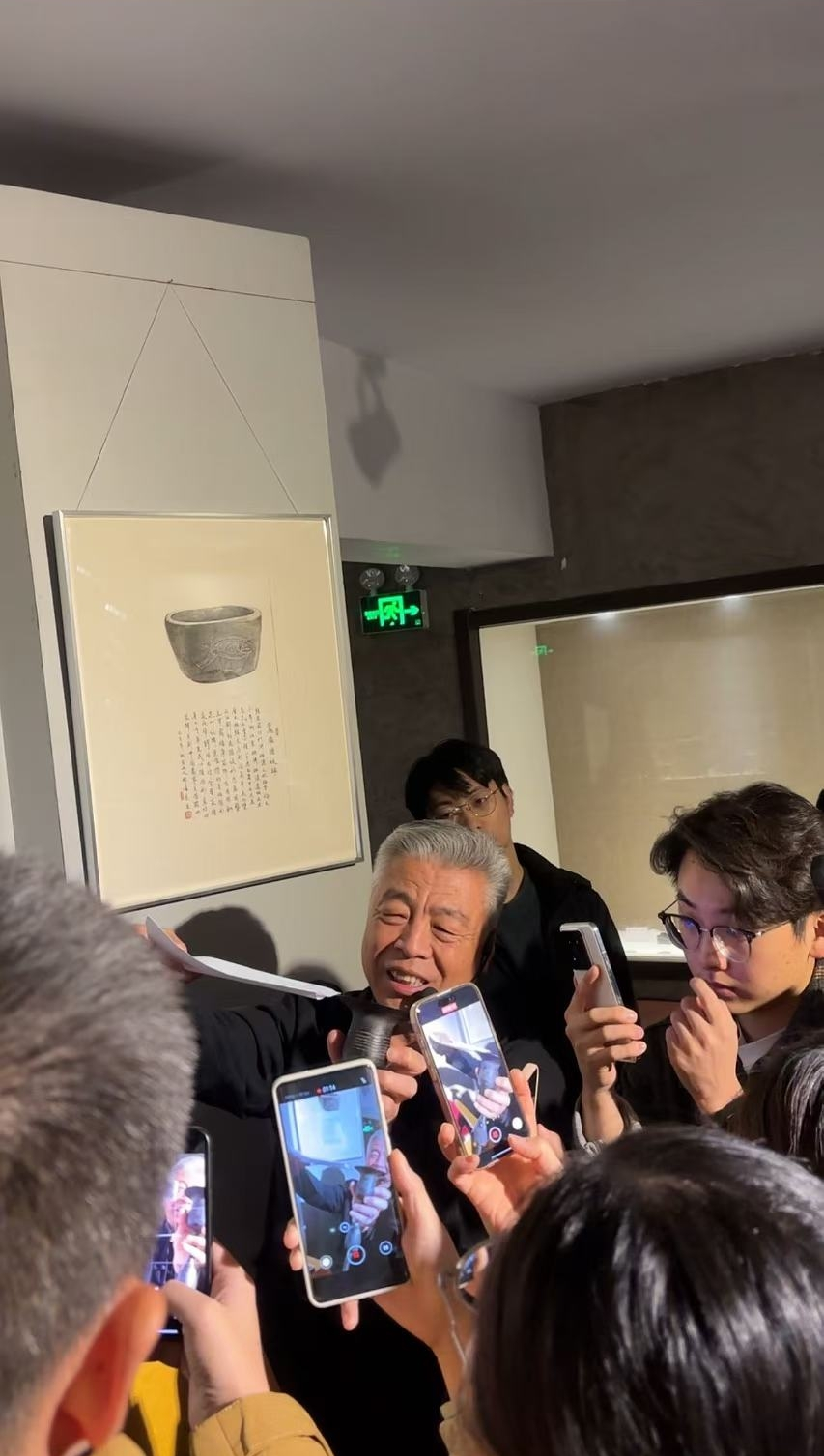 黑陶邢文化博物館館長邢葆東展示兩張相疊的A4紙，向記者解釋此為杯口的厚度。