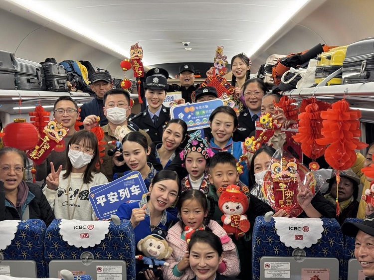 春節(jié)期間，在中老鐵路磨萬（磨丁—萬象）段，鐵路客運員工與乘客合影留念。李加勇攝