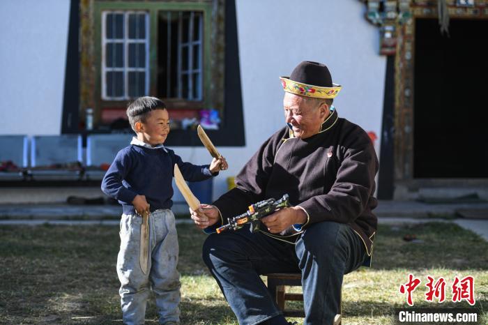 圖為米林縣扎西繞登鄉(xiāng)彩門(mén)村64歲的洛桑帶著孫子巴桑在院子的草地上玩耍。　何蓬磊 攝