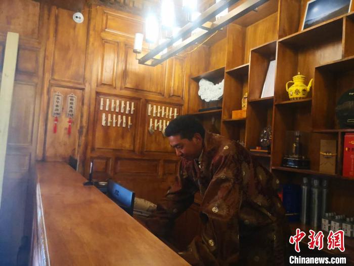 圖為桑杰才讓用電腦處理財務(wù)。　史靜靜 攝