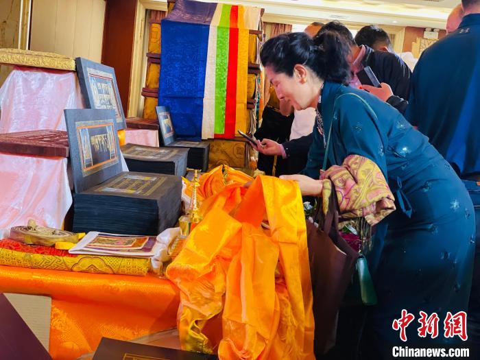 圖為現(xiàn)場藏族民眾向黃金書寫的大藏經(jīng)《甘珠爾》敬獻哈達?！O睿 攝