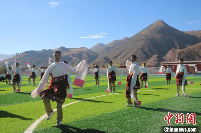 圖為青海師范大學(xué)附屬玉樹實驗學(xué)校學(xué)生在綠茵場跳起囊謙古舞—卓根瑪。　程雨 攝