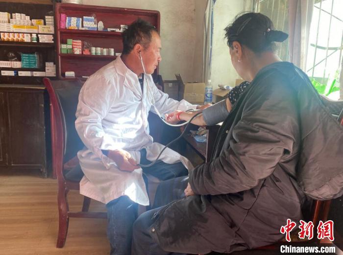 索木滾(左)為村民看病?！∪捞量h委宣傳部供圖