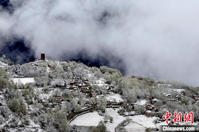 雪后的藏寨和碉樓構(gòu)成美麗的雪景?！〗党鯘衫?攝
