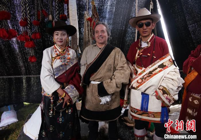 圖為一名外籍攝影師(中)身穿藏服和藏族民眾合影留念?！●R銘言 攝