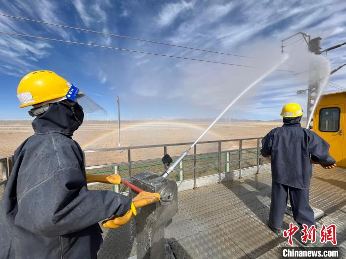 圖為水炮手操作高壓水槍對(duì)絕緣子進(jìn)行清洗。　高啟宏 攝