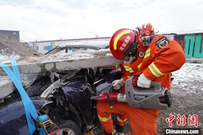 圖為地震實戰(zhàn)拉動現(xiàn)場，參演人員進(jìn)行車輛破拆?！∮駱湎拦﹫D