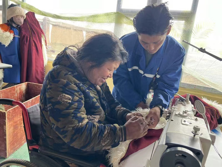 扎西奪爾登幫助殘疾員工裁剪。阿壩州文明辦供圖