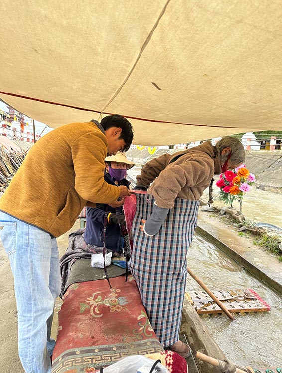 扎西奪爾登為路邊老人送去保暖圍腰。阿壩州文明辦供圖
