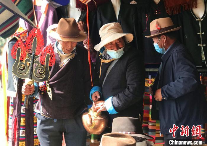 圖為三位藏族老人在集市上聊天交談。　冉文娟 攝