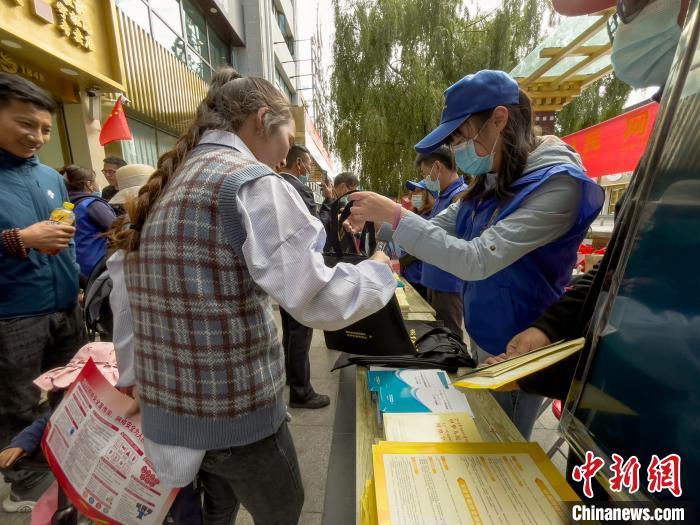 圖為志愿者為市民發(fā)放網(wǎng)絡(luò)安全宣傳手冊。　謝牧 攝