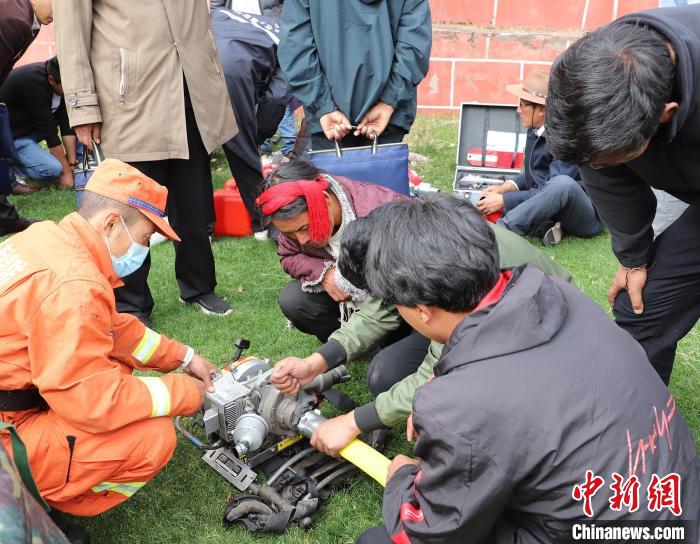 圖為森林消防員為護林員講解滅火裝備的使用方法?！〔际猩窒乐ш?供圖