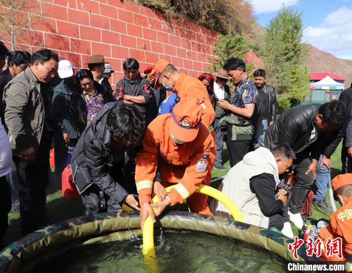 圖為森林消防員為護林員講解滅火裝備的使用方法。　昌都市森林消防支隊 供圖
