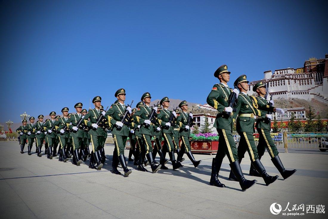 國旗護衛(wèi)隊隊員緊握鋼槍，踏著威武雄壯的步伐，走向國旗臺。人民網(wǎng) 次仁羅布攝