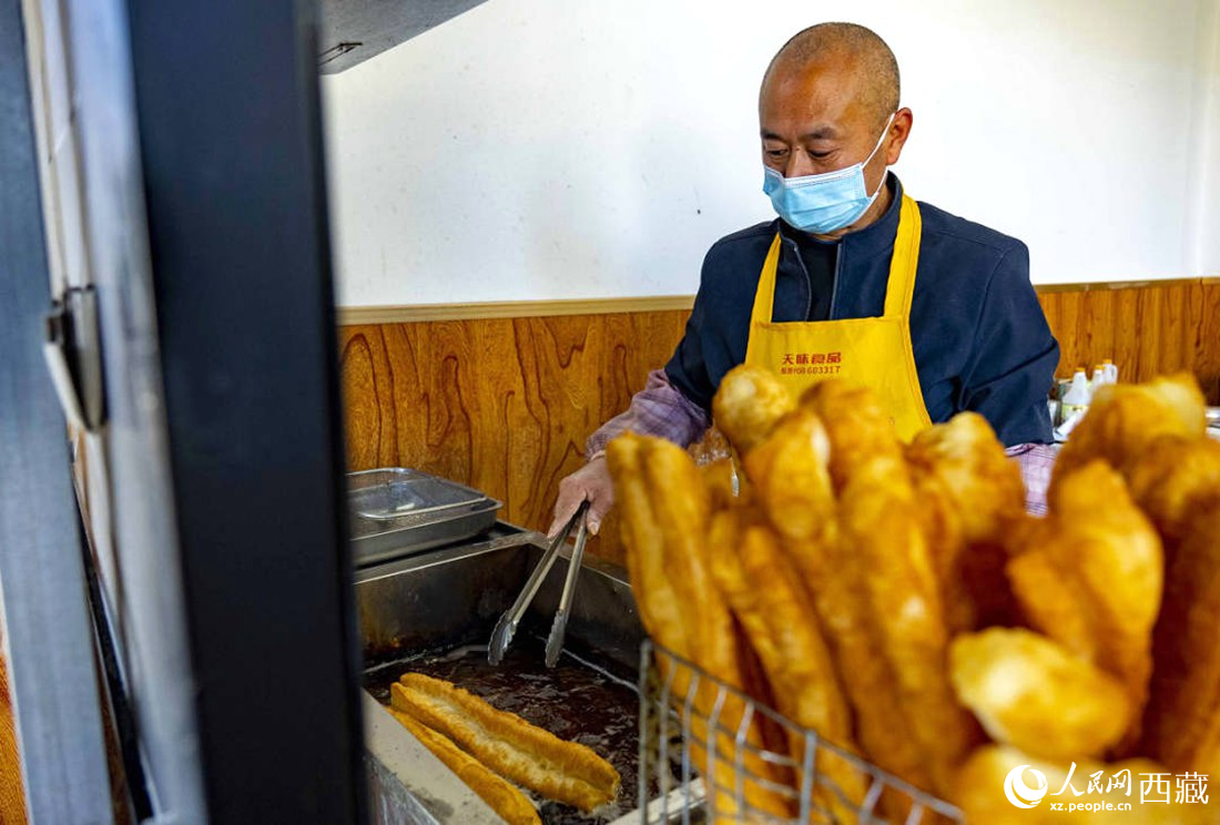 早餐店老板正在炸油條。人民網(wǎng) 次仁羅布攝