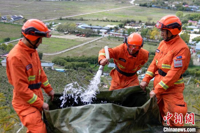 技能大練兵過程中，消防員在陡坡上向蓄水池注水?！±顕鵂c 攝