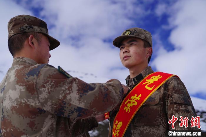 排長王朝偉(圖左)給退伍老兵佩戴大紅花。　西藏山南軍分區(qū)某團(tuán)供圖