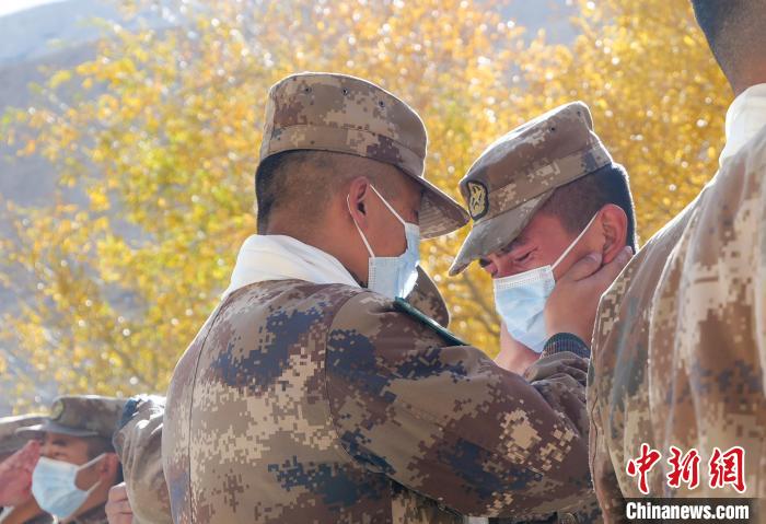 圖為什布奇邊防連退伍老兵與戰(zhàn)友相擁而泣，依依惜別?！⌒觳?攝