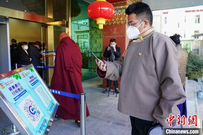圖為政協(xié)委員掃場所碼進(jìn)入會場?！〗w波 攝
