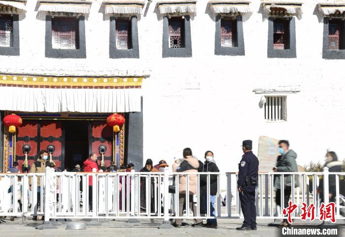 圖為1月23日，布達(dá)拉宮廣場(chǎng)派出所民警正在引導(dǎo)游客?！∝暩聛?lái)松 攝