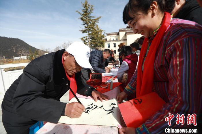 圖為林芝市文聯(lián)書法家協(xié)會(huì)會(huì)員向民眾贈(zèng)送藏文書法作品?！埩?攝