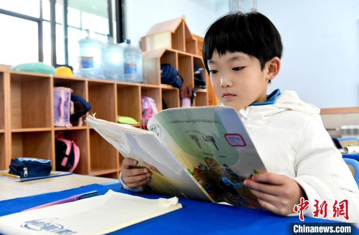3月14日，西藏拉薩市第一小學(xué)一年級(jí)六班學(xué)生丁增樂(lè)吉在閱讀藏語(yǔ)課本?！±盍?攝