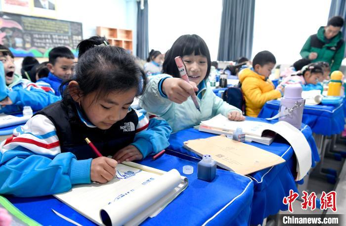 3月14日，西藏拉薩市第一小學(xué)一年級(jí)六班學(xué)生白瑪朗珍(圖左)在藏語(yǔ)文課上書(shū)寫(xiě)藏文。　李林 攝