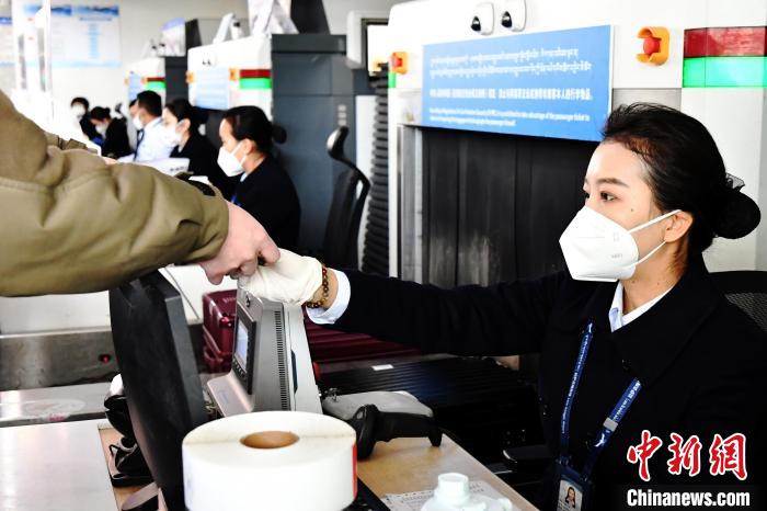 圖為機場工作人員為旅客辦理行李托運?！≈芎?攝