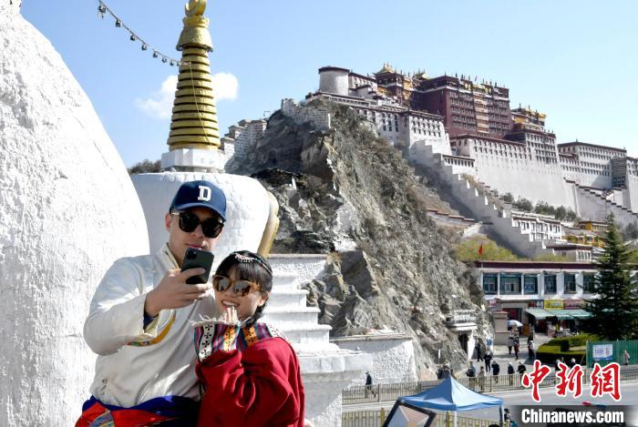 4月17日，游客身著藏式元素服裝在拉薩布達(dá)拉宮觀景臺(tái)拍照留念?！±盍?攝