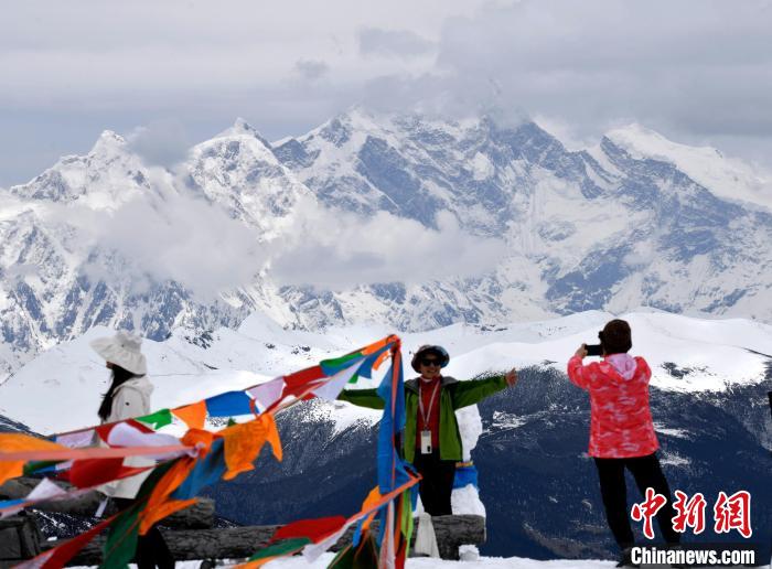 圖為5月14日，西藏林芝色季拉山觀景臺(tái)，游客與南迦巴瓦峰合影?！±盍?攝