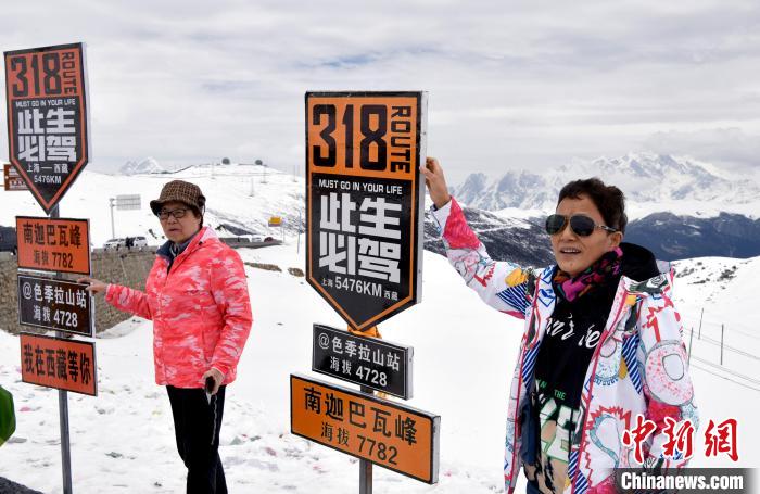 圖為5月14日，西藏林芝色季拉山觀景臺(tái)，游客與南迦巴瓦峰合影?！±盍?攝