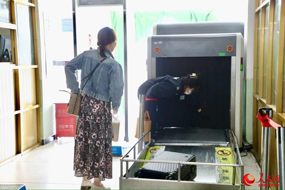 車站工作人員幫旅客提取行李。人民網(wǎng)記者 次仁羅布攝