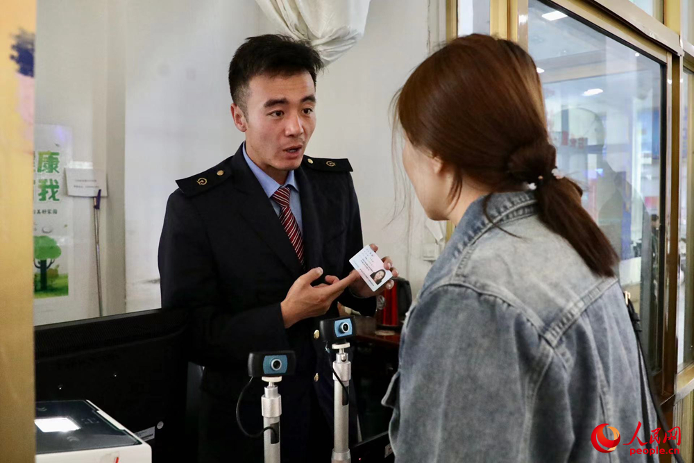 車站工作人員向旅客解答疑問。人民網(wǎng)記者 次仁羅布攝