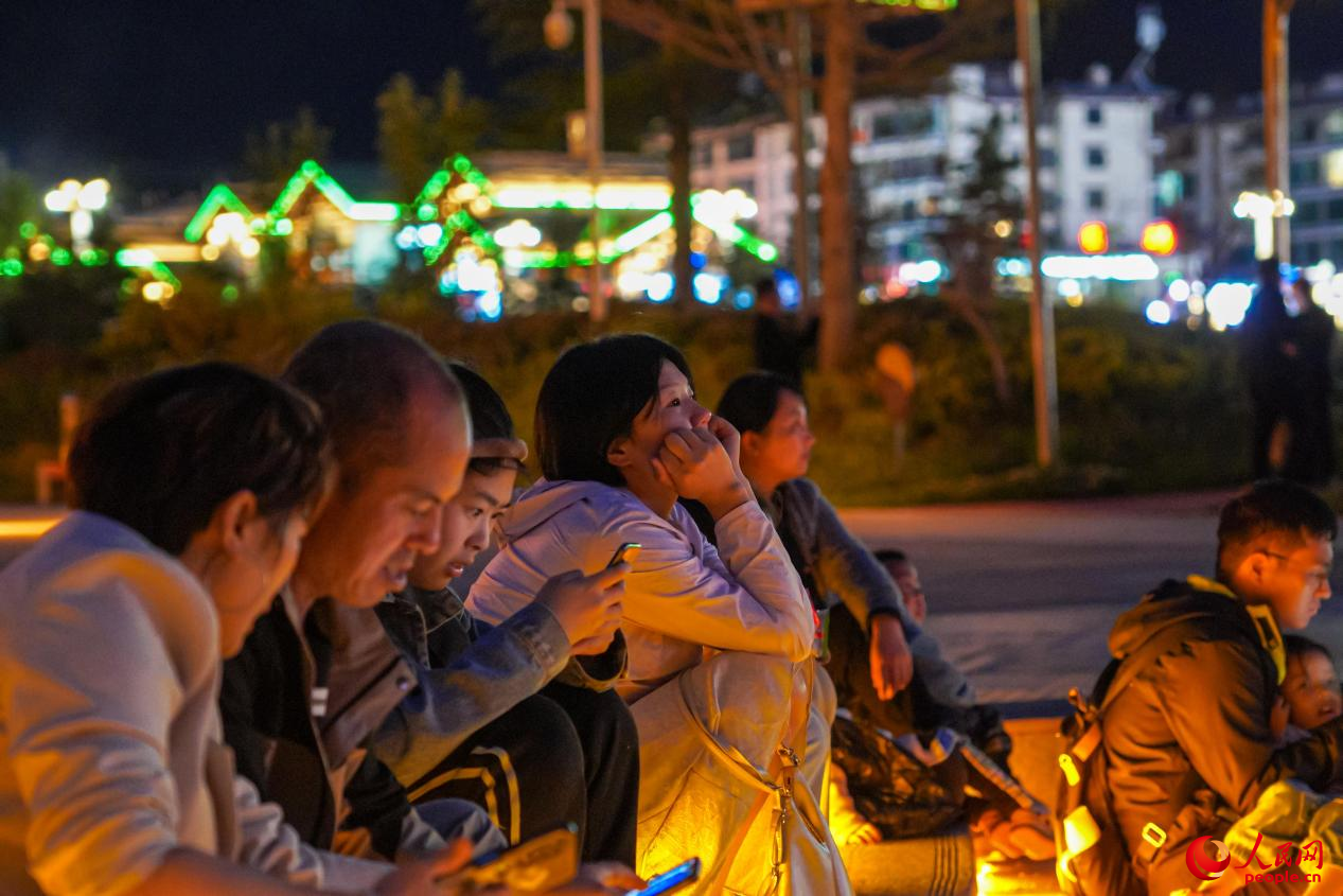 市民坐在西藏林芝市民族團結廣場臺階上欣賞音樂噴泉。人民網(wǎng)記者 趙晨攝